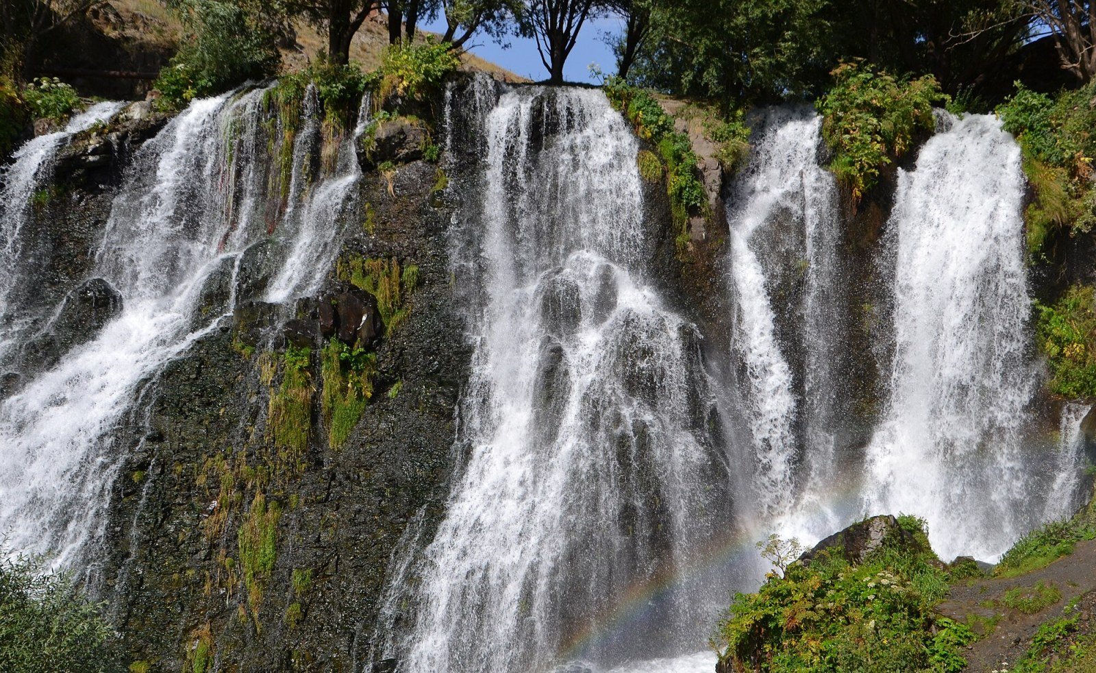 Frontansicht des Wasserfalls Shaki mit Ufervegetation im Vordergrund