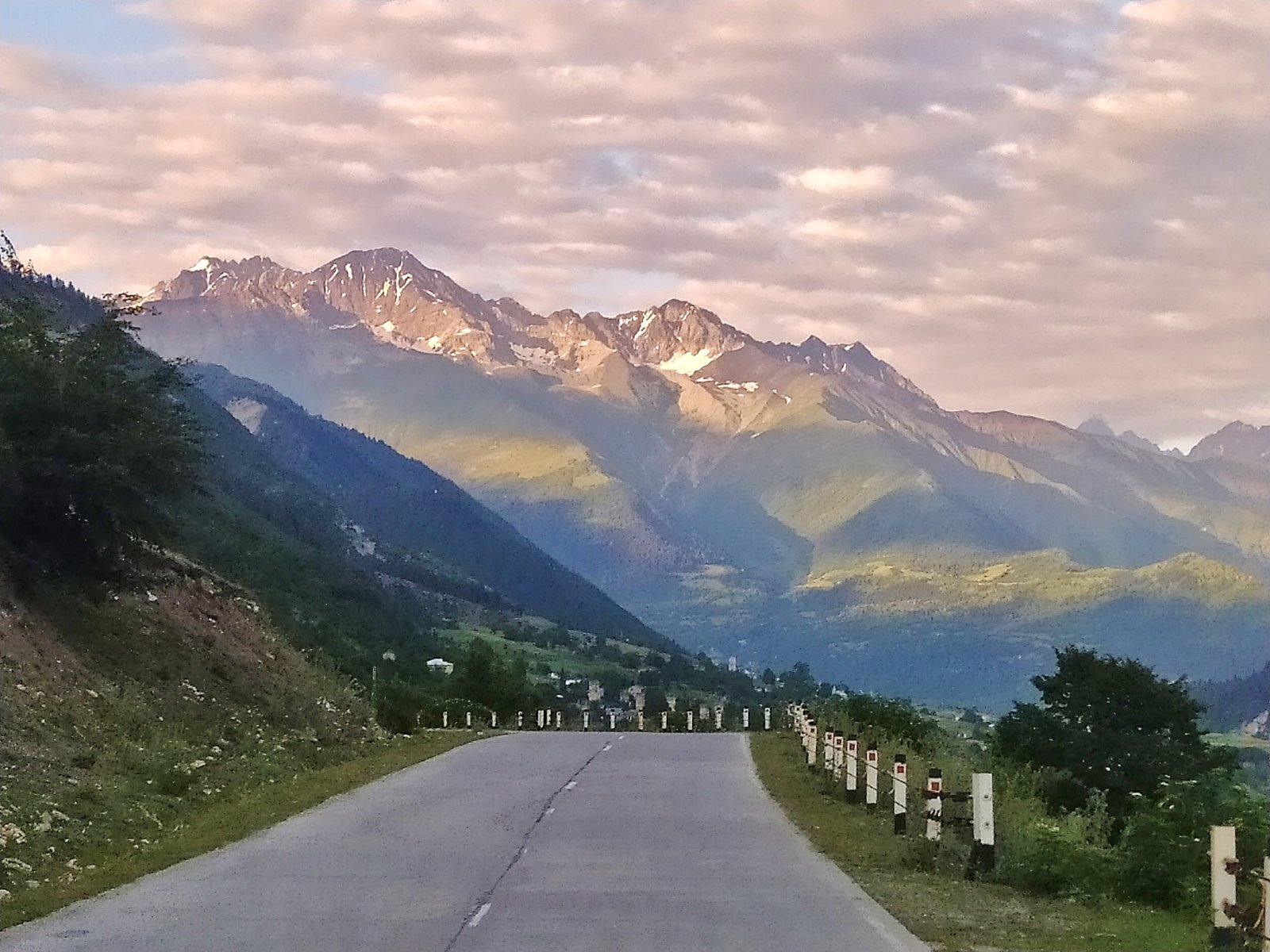 Paisaje de montañas del Cáucaso en Georgia con la iglesia de Gergeti al fondo, símbolo de los sorprendentes peligros de viajar a Georgia