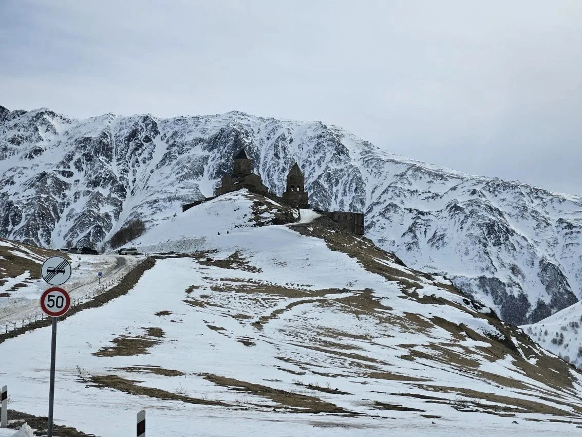 Chiesa di Gergeti di fronte al monte Kazbek Chiesa della Trinità di Gergeti con il monte Kazbek innevato sullo sfondo, icona del turismo religioso in Georgia