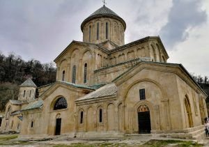 Vista frontal de la histórica Academia de Gelati bajo un cielo azul claro, reflejando su importancia como patrimonio cultural en Georgia.