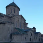 ista panorámica de Kutaisi al atardecer, con el río Rioni y la Catedral de Bagrati iluminada