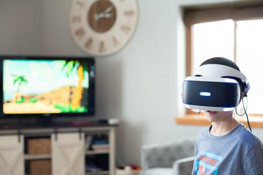 Criança usando um capacete de realidade virtual em uma sala de estar, com uma televisão mostrando uma cena tropical ao fundo